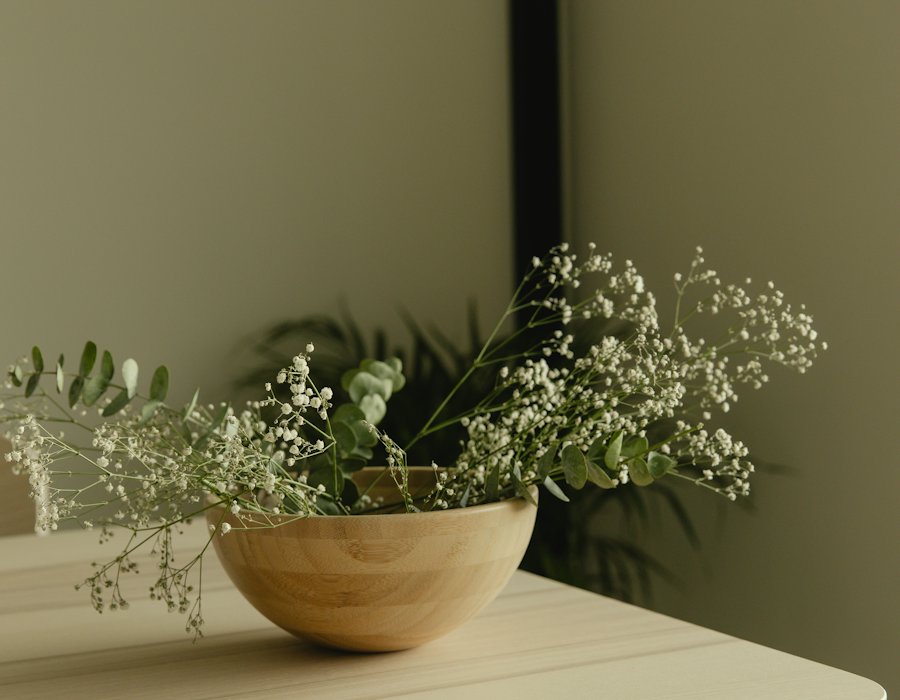 Taça de madeira com flores sobre uma mesa